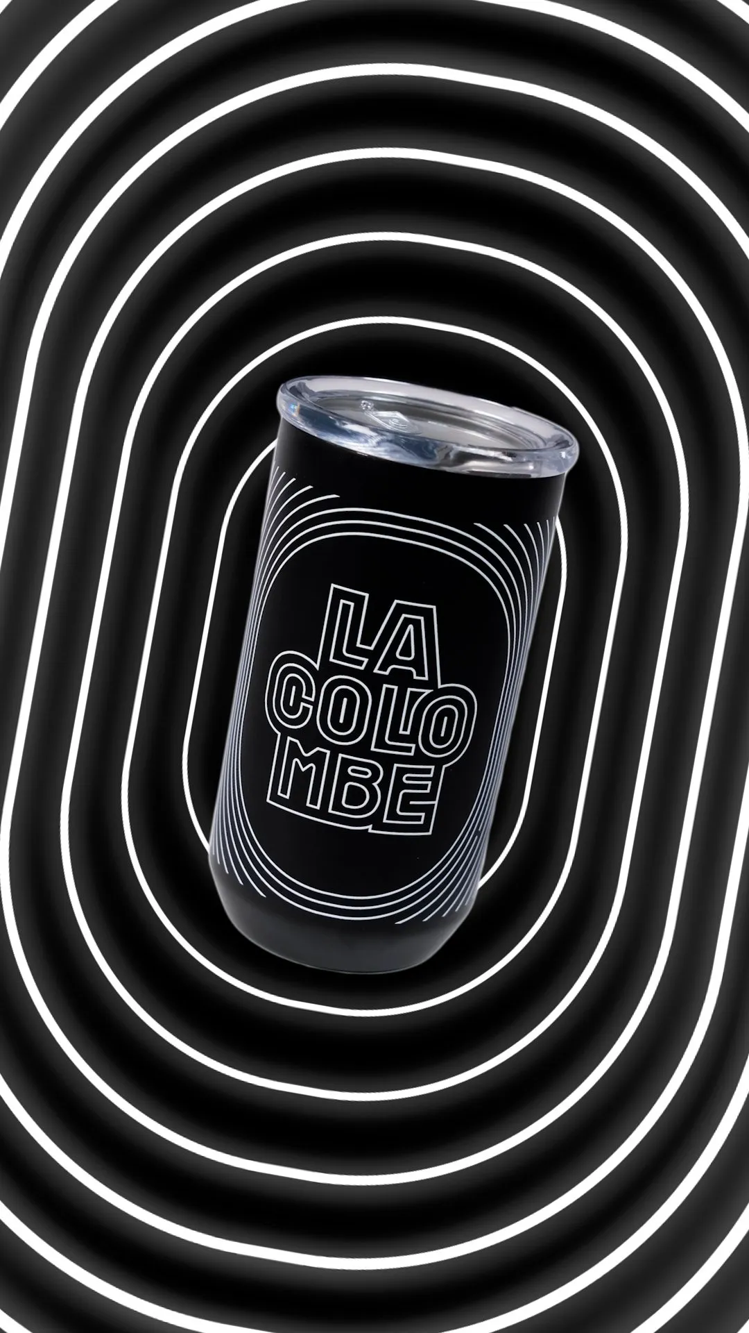 A black Created Co. tumbler with LA COLOMBE branding, set against a hypnotic black and white background.