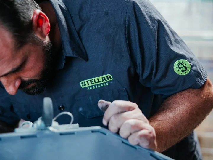 Close-up of a Stellar Surfaces technician meticulously working on a concrete surface, emphasizing their attention to detail and commitment to craftsmanship.
